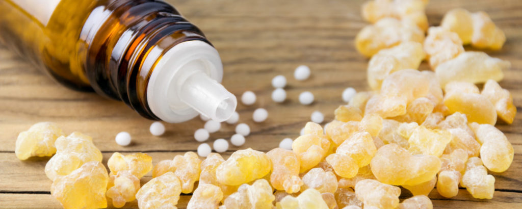 Frankincense and globules against wooden background